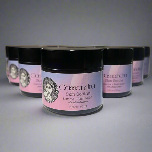 Jars of Cassandra Skin Soothe cream on a white surface with a gray background